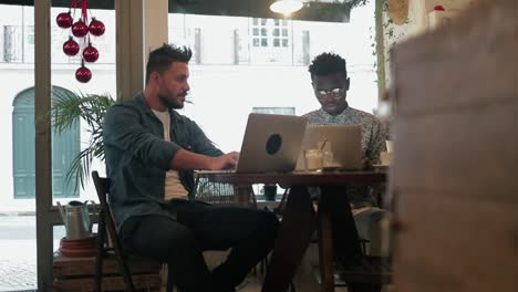 Multiethnic-freelancers-using-laptops-in-coffee-shop